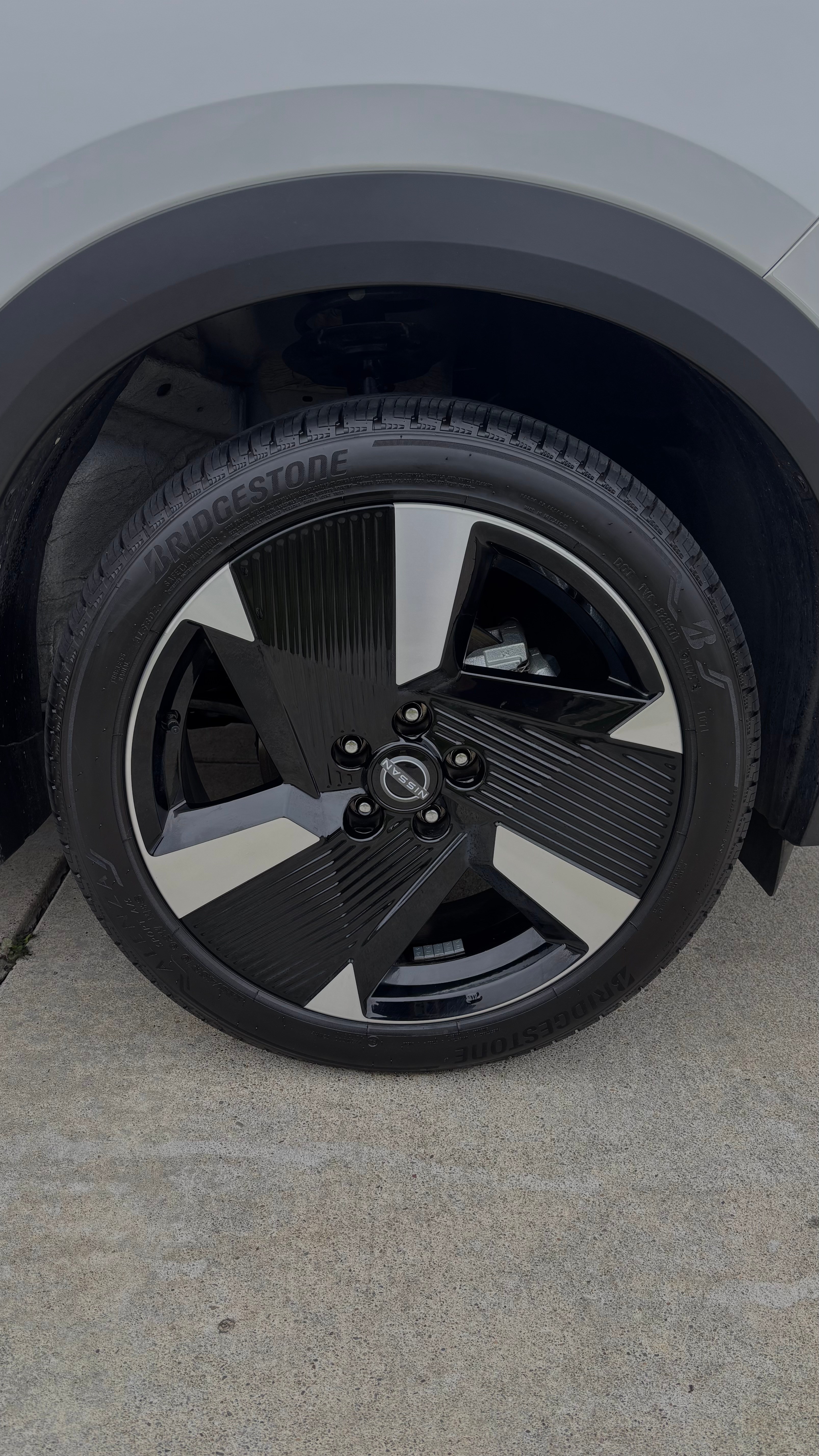 Nissan wheel and tire close-up, cleaned and dressed with Bridgestone tire